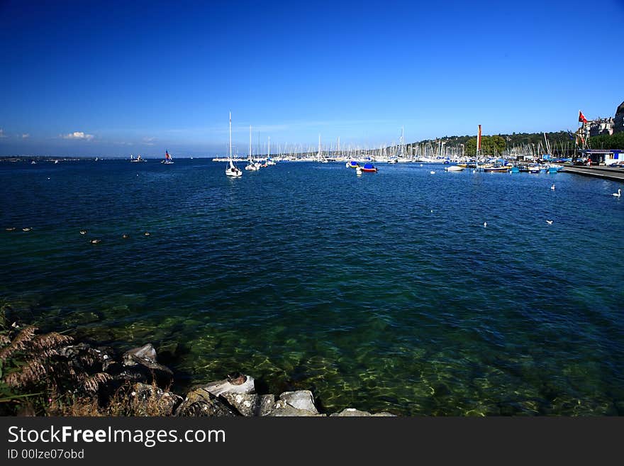 The blue water and the white masts on sailboat at the far side of the lake forms a beautiful picture.