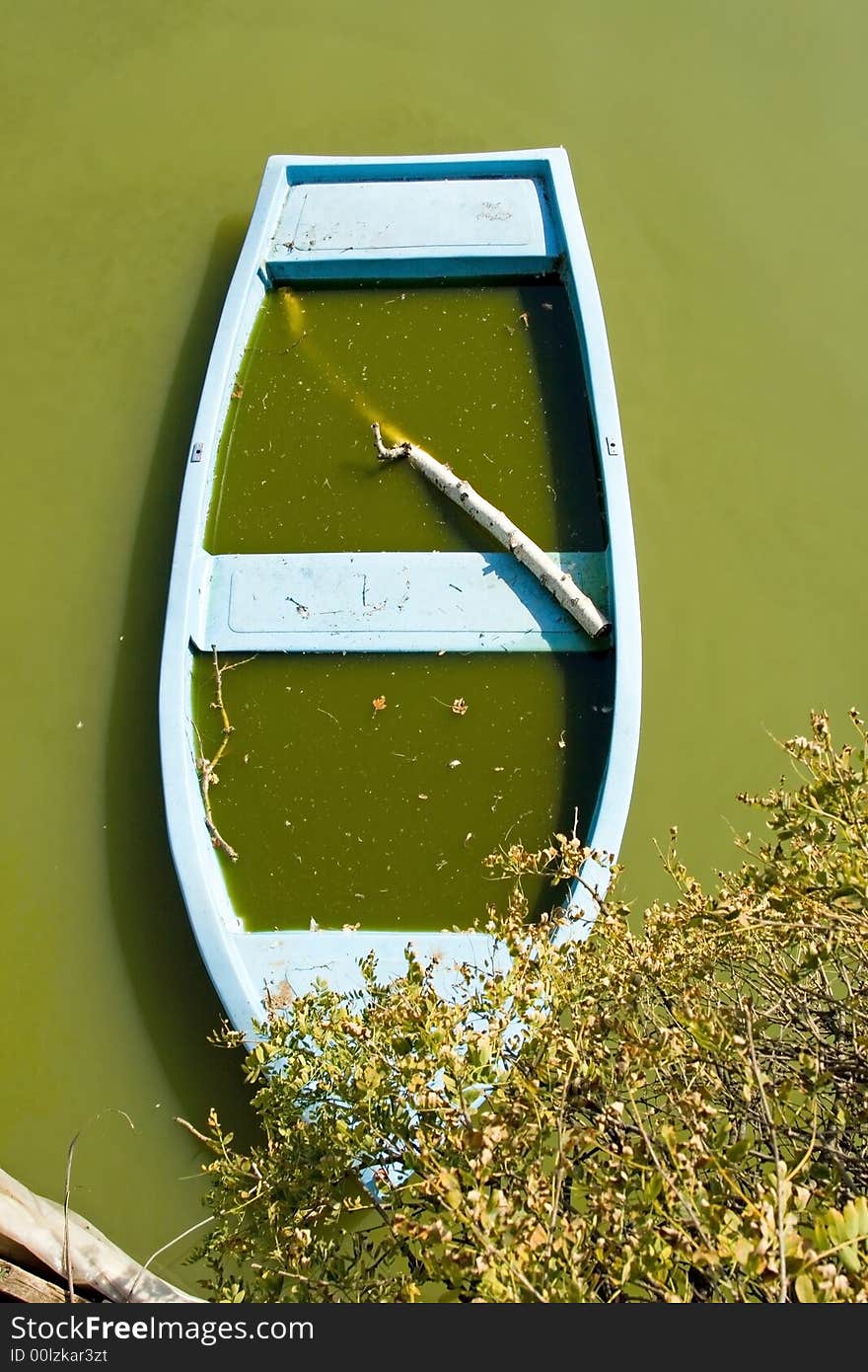 A boat leafed on the lake of a park. A boat leafed on the lake of a park.