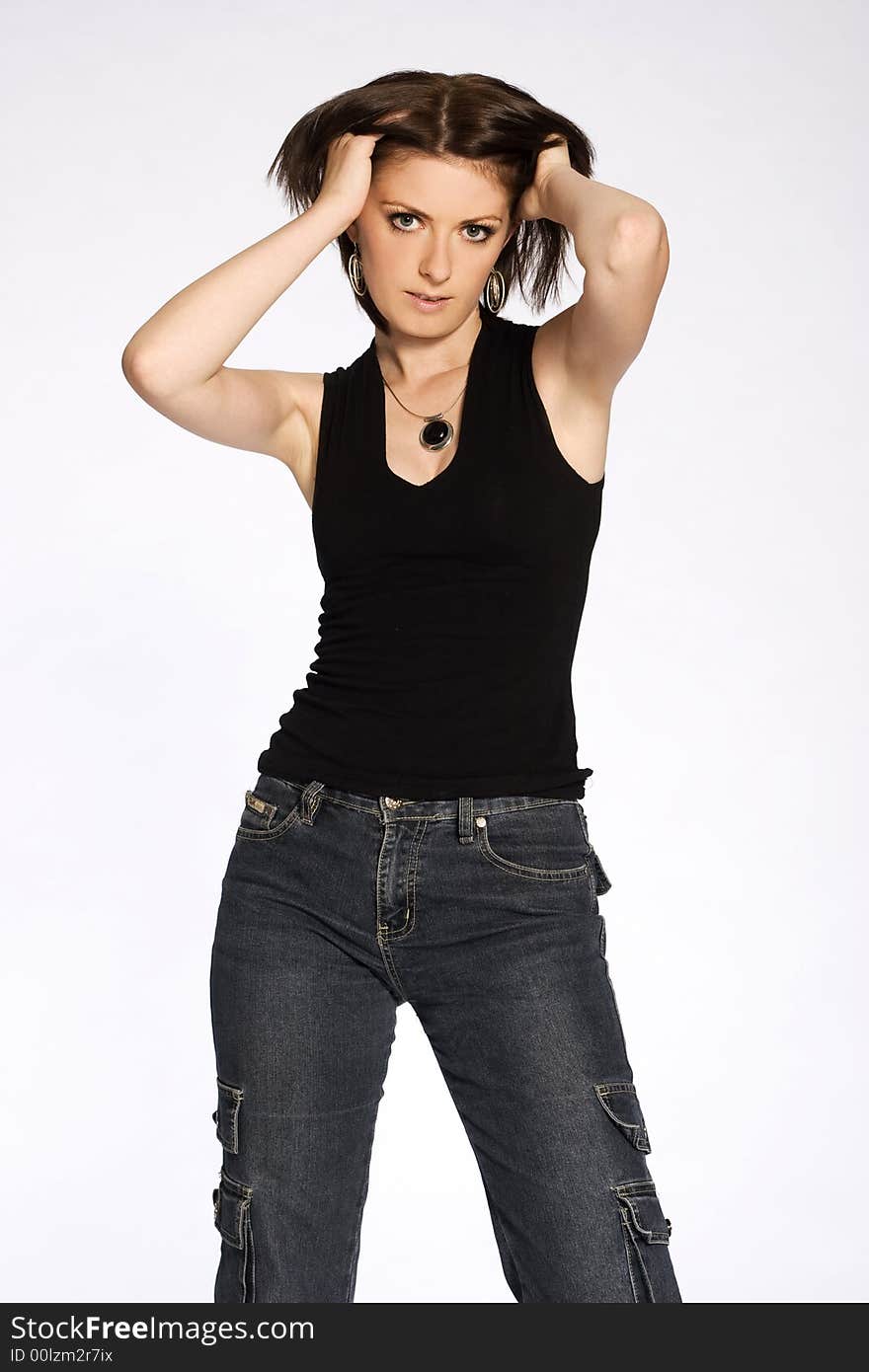 A beautiful brunette girl wearing jeans and black glouse standing on white background