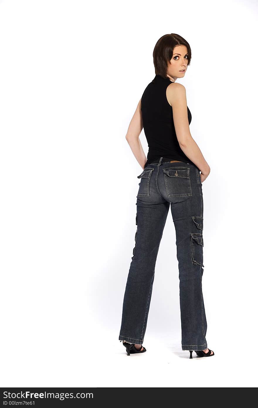 A beautiful brunette girl wearing jeans and black glouse standing on white background