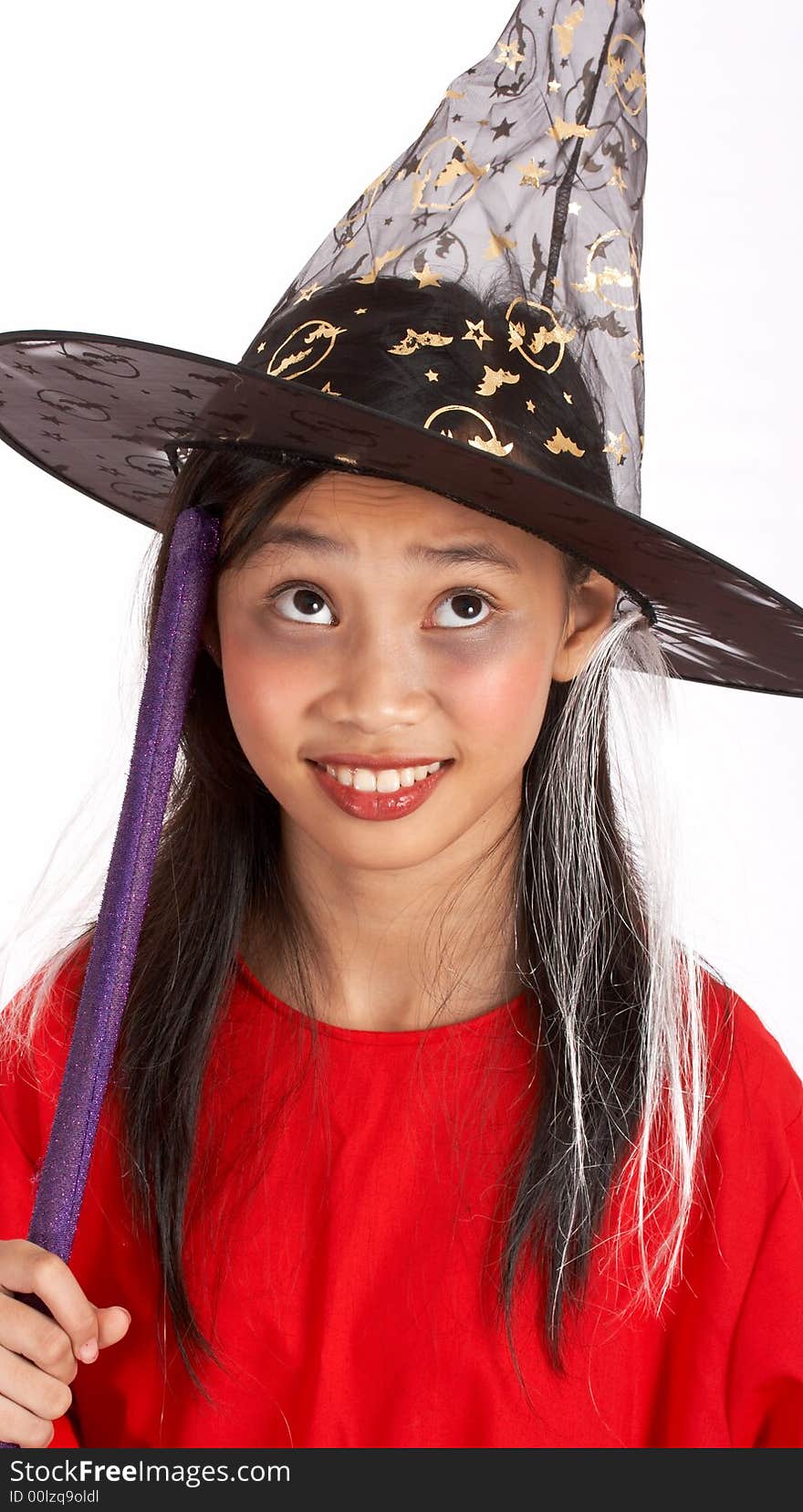 A young girl dressed in a witch costume