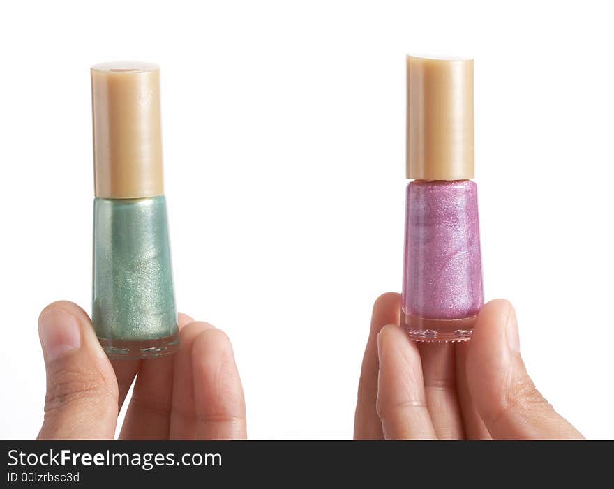 Holding bottles of nail polish over a white background