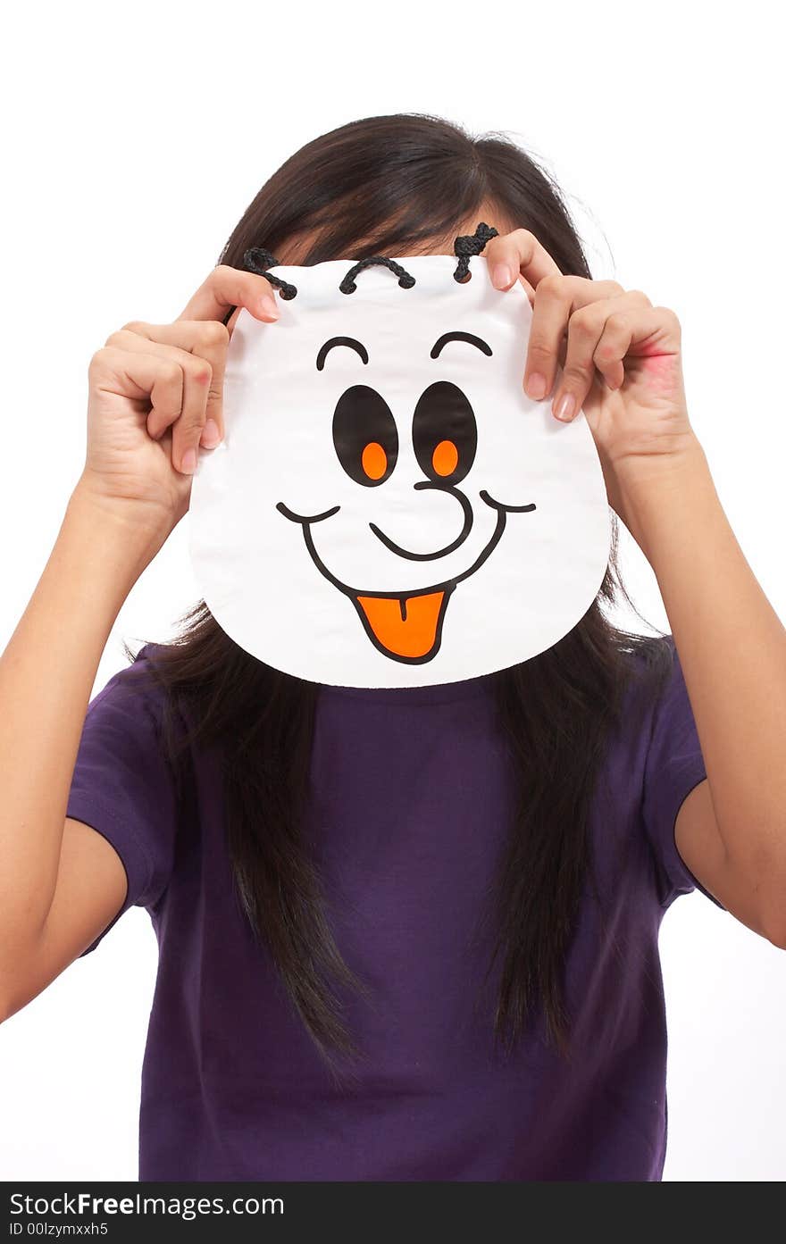 A girl holding a halloween bag covering her face. A girl holding a halloween bag covering her face