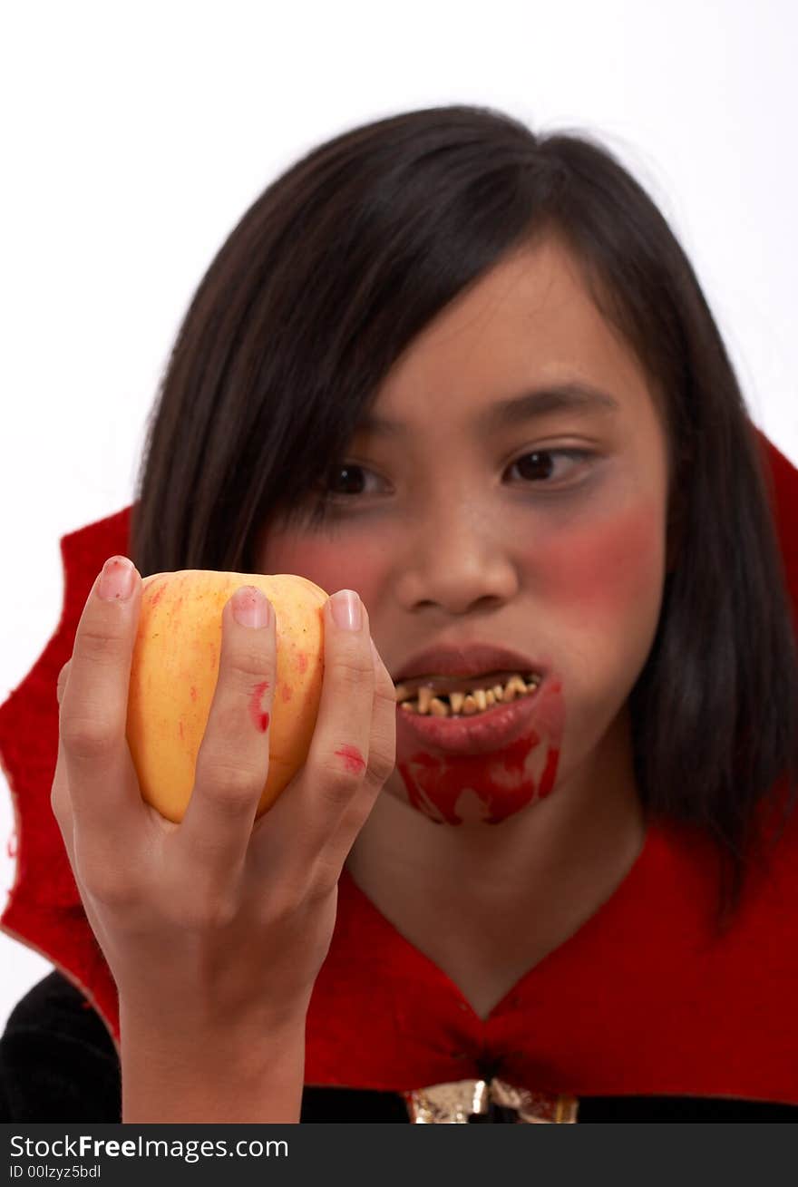 A vampire with a bloody mouth holding an apple. A vampire with a bloody mouth holding an apple