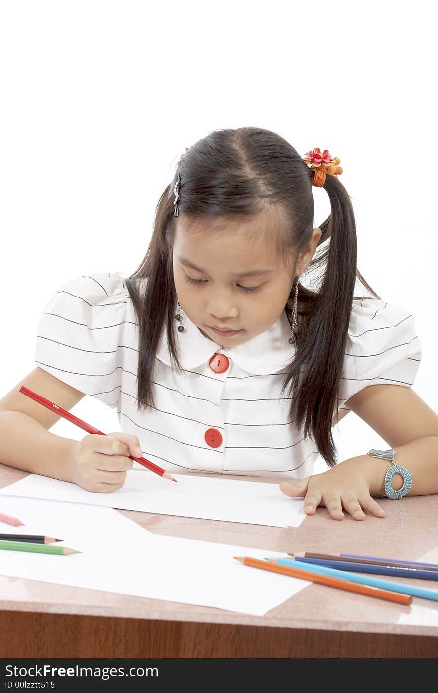 A young girl drawing on a white piece of paper