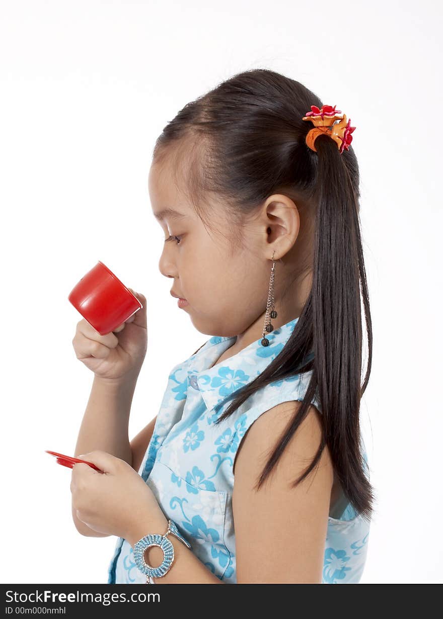 Girl playing with a toy tea cup and saucer