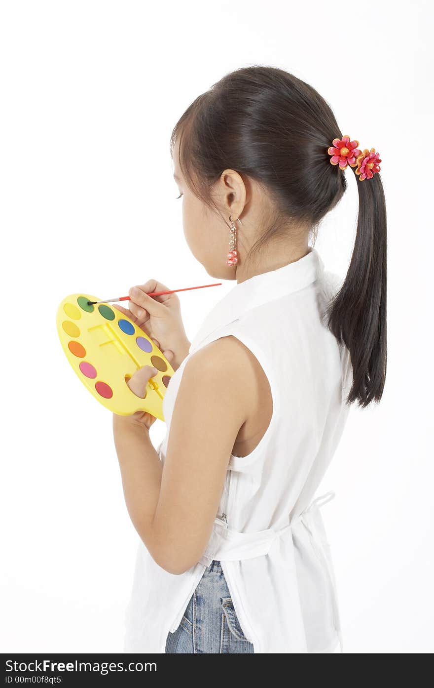 A girl holding a paint brush and a pallete. A girl holding a paint brush and a pallete