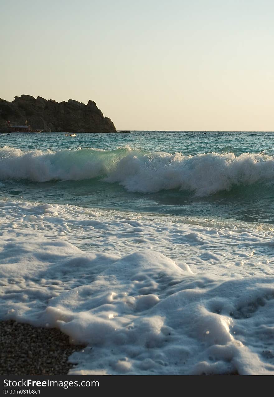 Waves of the azure Mediterranian sea rolling on the pebble beach. Waves of the azure Mediterranian sea rolling on the pebble beach