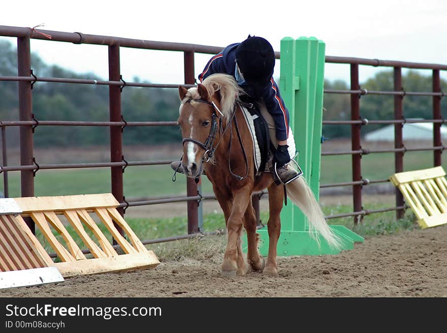 Small child leaning to pet pony after a ride in show. Small child leaning to pet pony after a ride in show