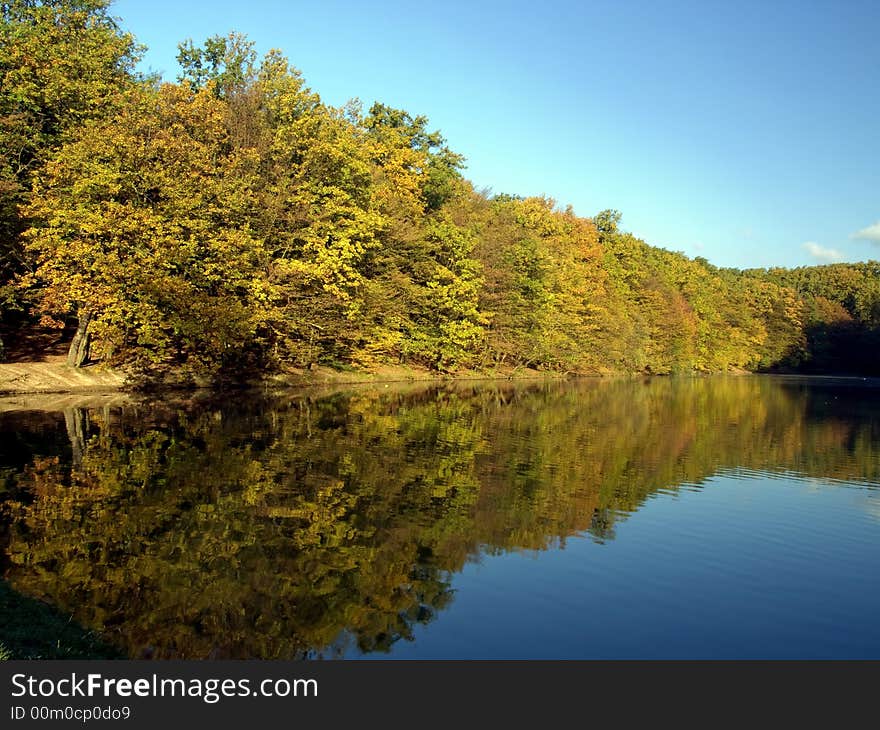 Autumn scene with trees reflecting in the water. Autumn scene with trees reflecting in the water.