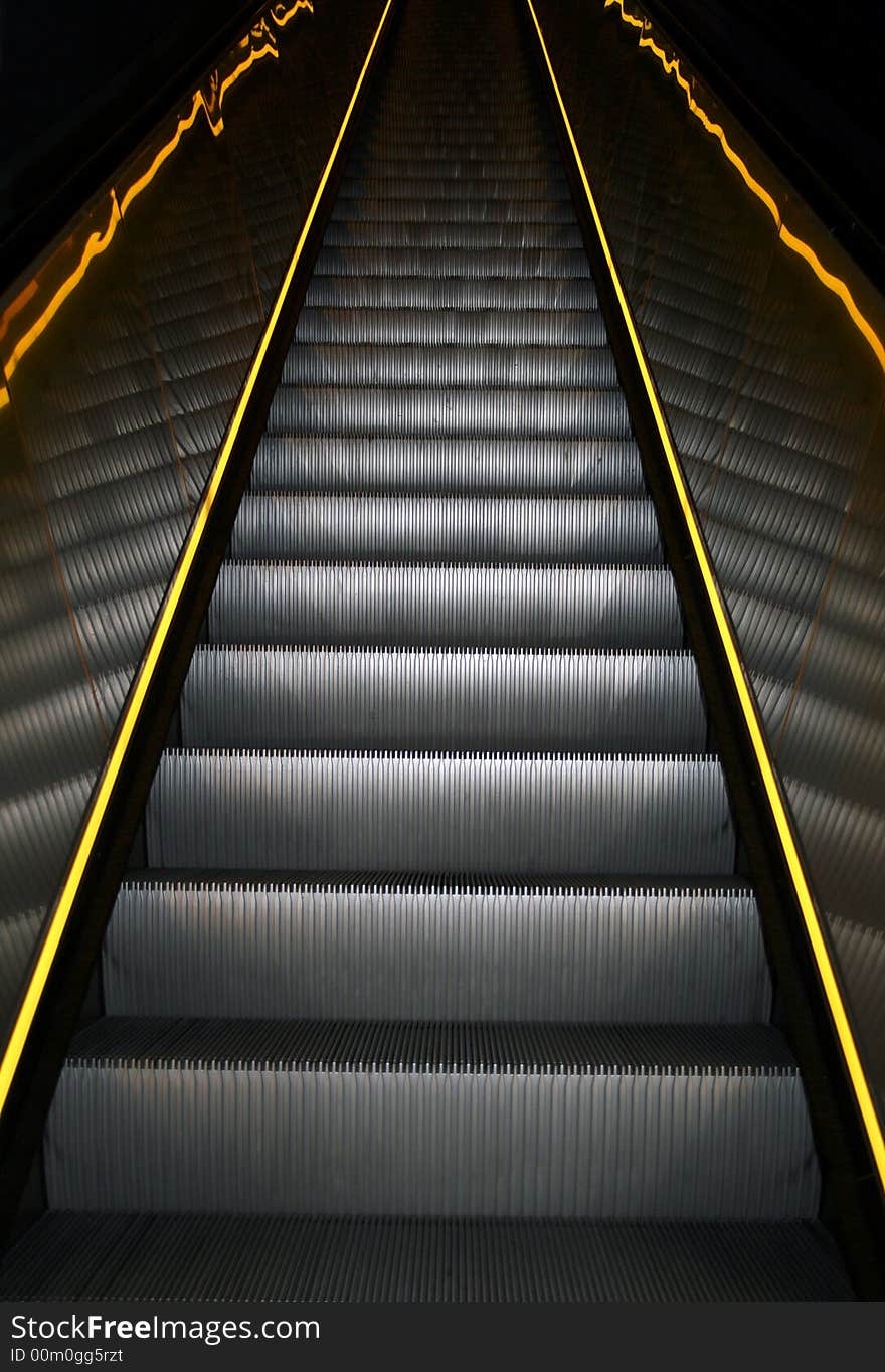 A escalator with yellow stripes on the sides