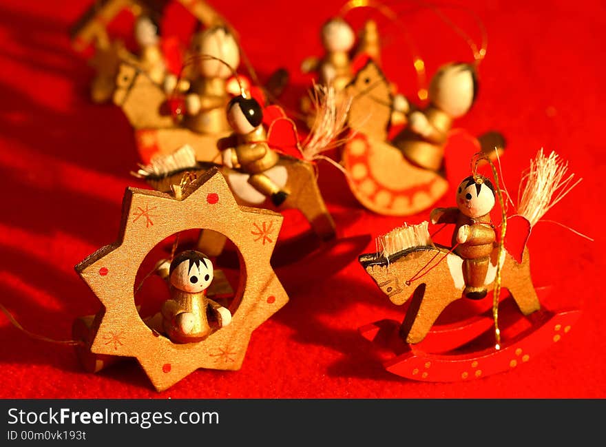 Little wooden new-year toys, wooden little angels on a red background