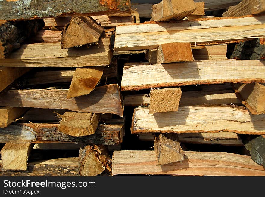 A stack of cut hardwood for fire place or stove in the winter. A stack of cut hardwood for fire place or stove in the winter