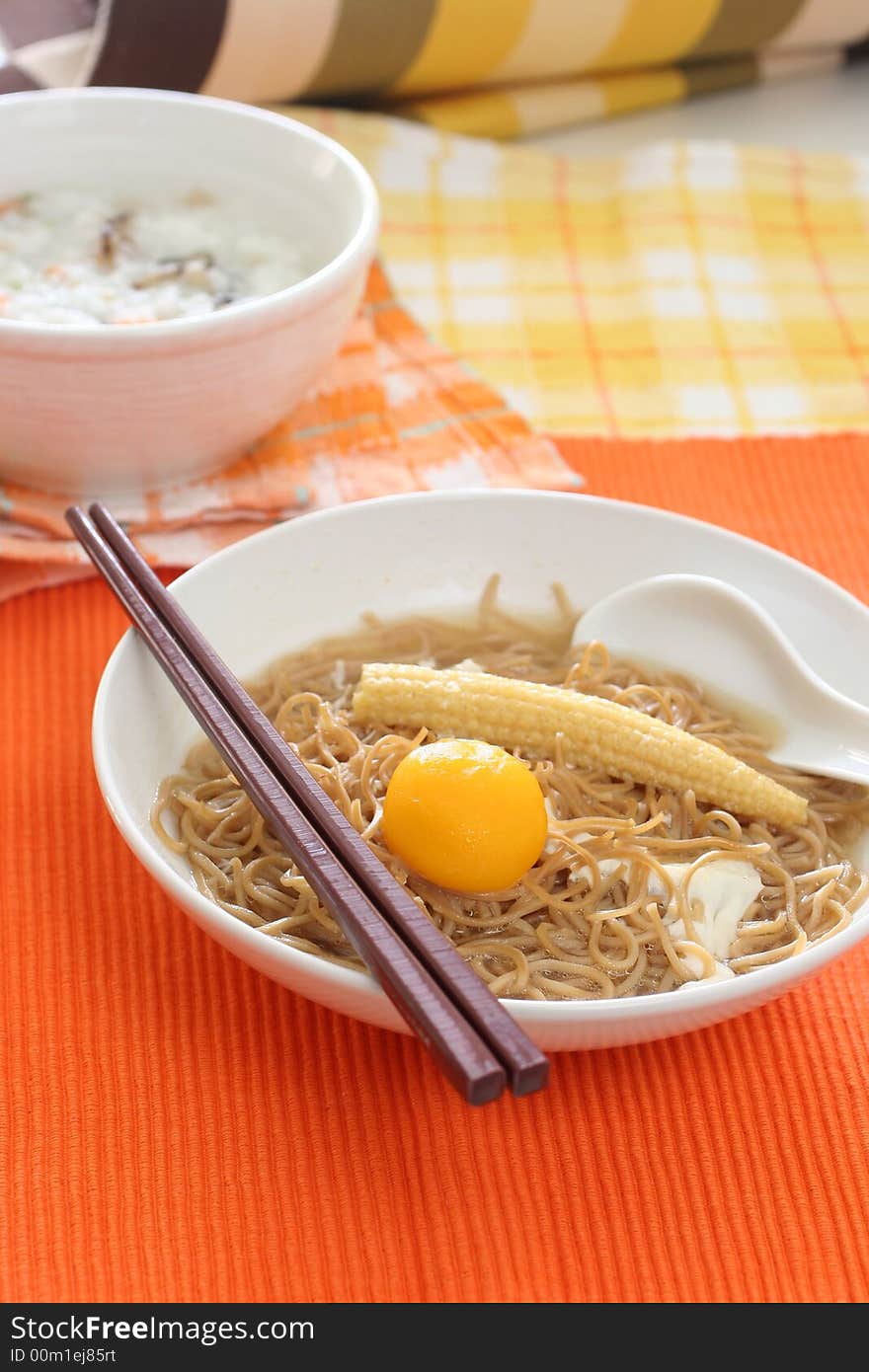 Brown Chinese buckwheat noodles with egg and baby corn in light soup