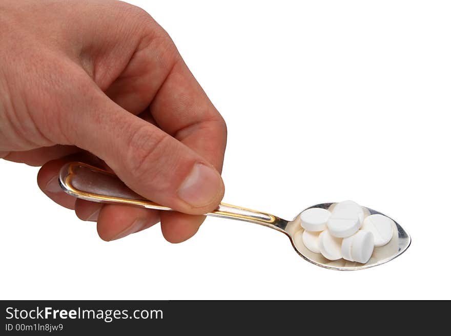 Spoon with pills in hand isolated on white