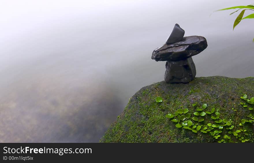 Stones arrangement on rock surface captured against natural stream of waterfall. Stones arrangement on rock surface captured against natural stream of waterfall.