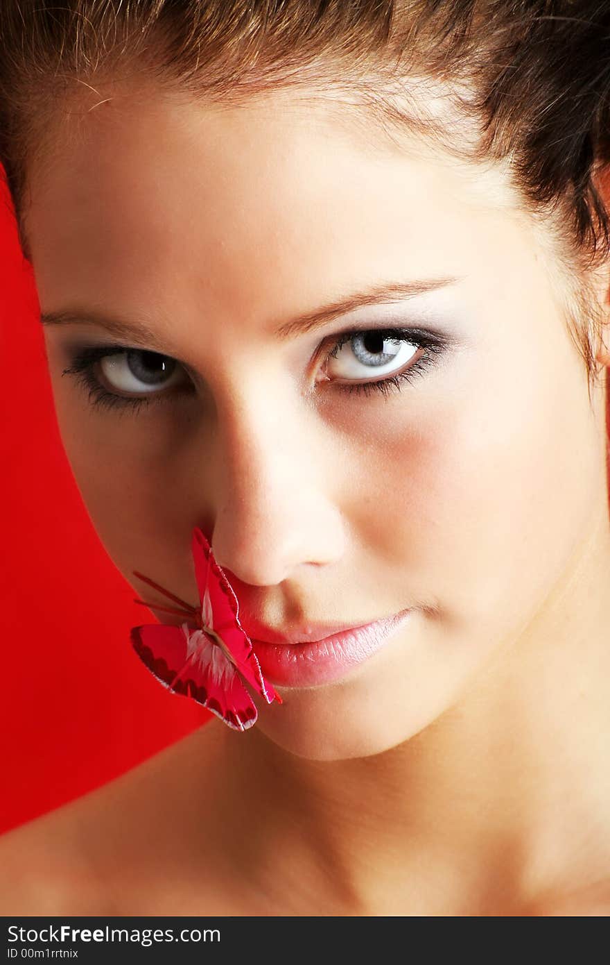 Beauty portrait of a beautiful young woman with a butterfly on her face. Beauty portrait of a beautiful young woman with a butterfly on her face