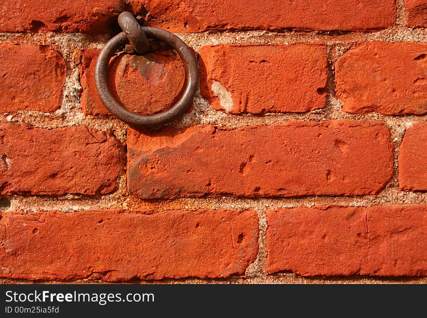 A Red Brick Wall with a Rusty Ring is Displayed. A Red Brick Wall with a Rusty Ring is Displayed.