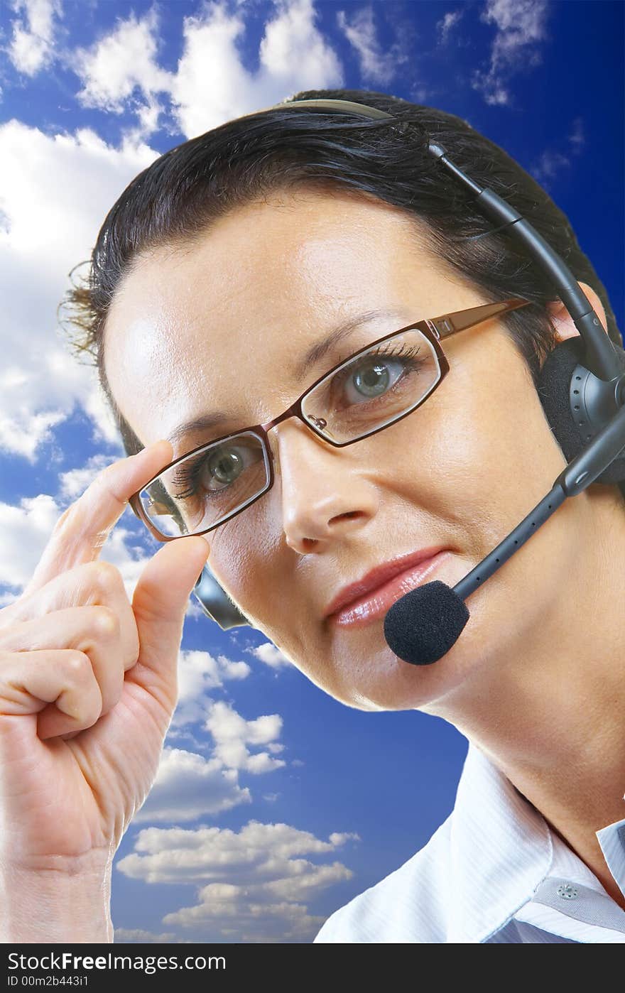 View of nice operator in stylish glasses on blue sky back. View of nice operator in stylish glasses on blue sky back