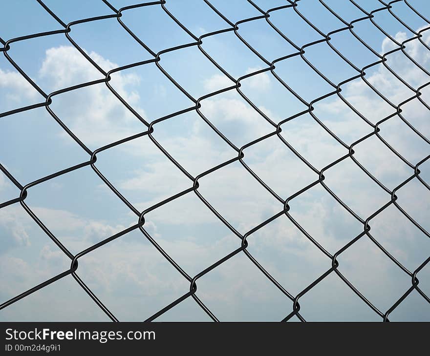 Metallic wire net with a blue sky on background