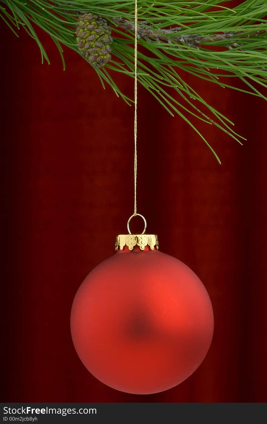 An image of a red Christmas ornament on a burgundy background