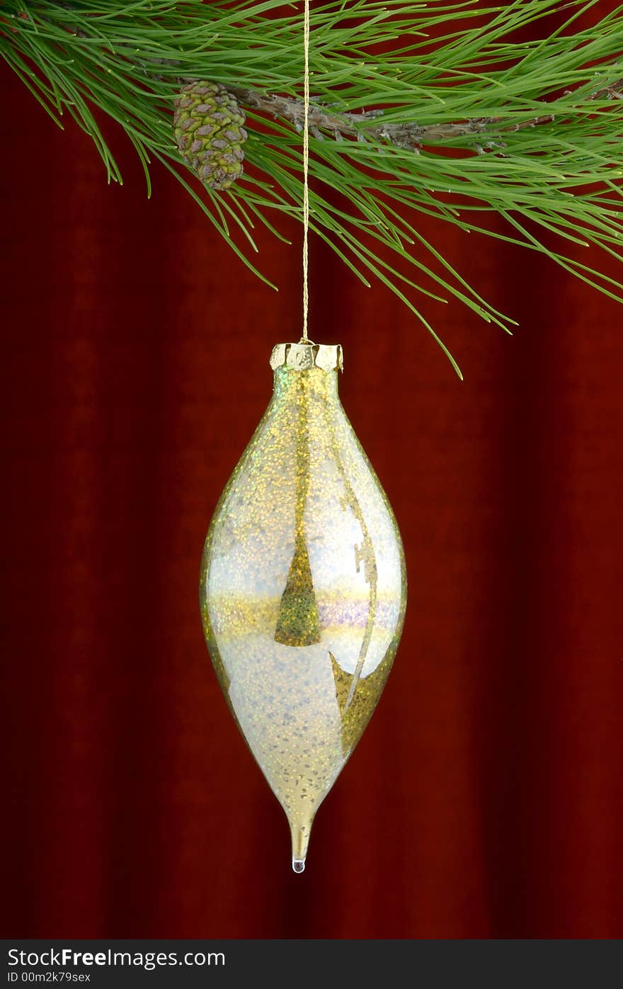 An image of gold Christmas ornaments on a burgundy background. An image of gold Christmas ornaments on a burgundy background