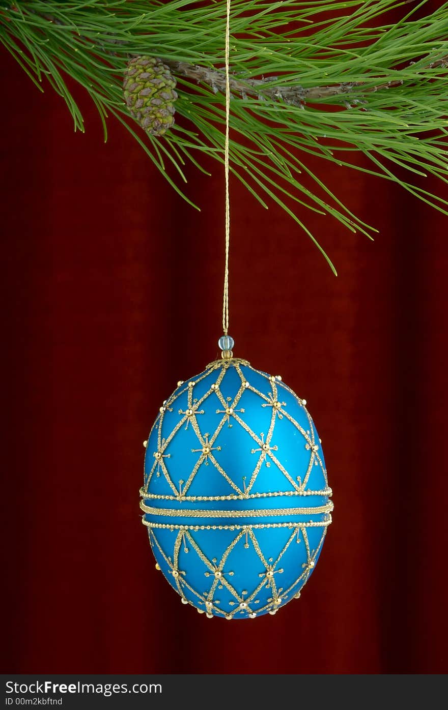 Christmas tree ornament with a pine tree branch in the top of the image, a blue hand made decoration being the main focus. Christmas tree ornament with a pine tree branch in the top of the image, a blue hand made decoration being the main focus