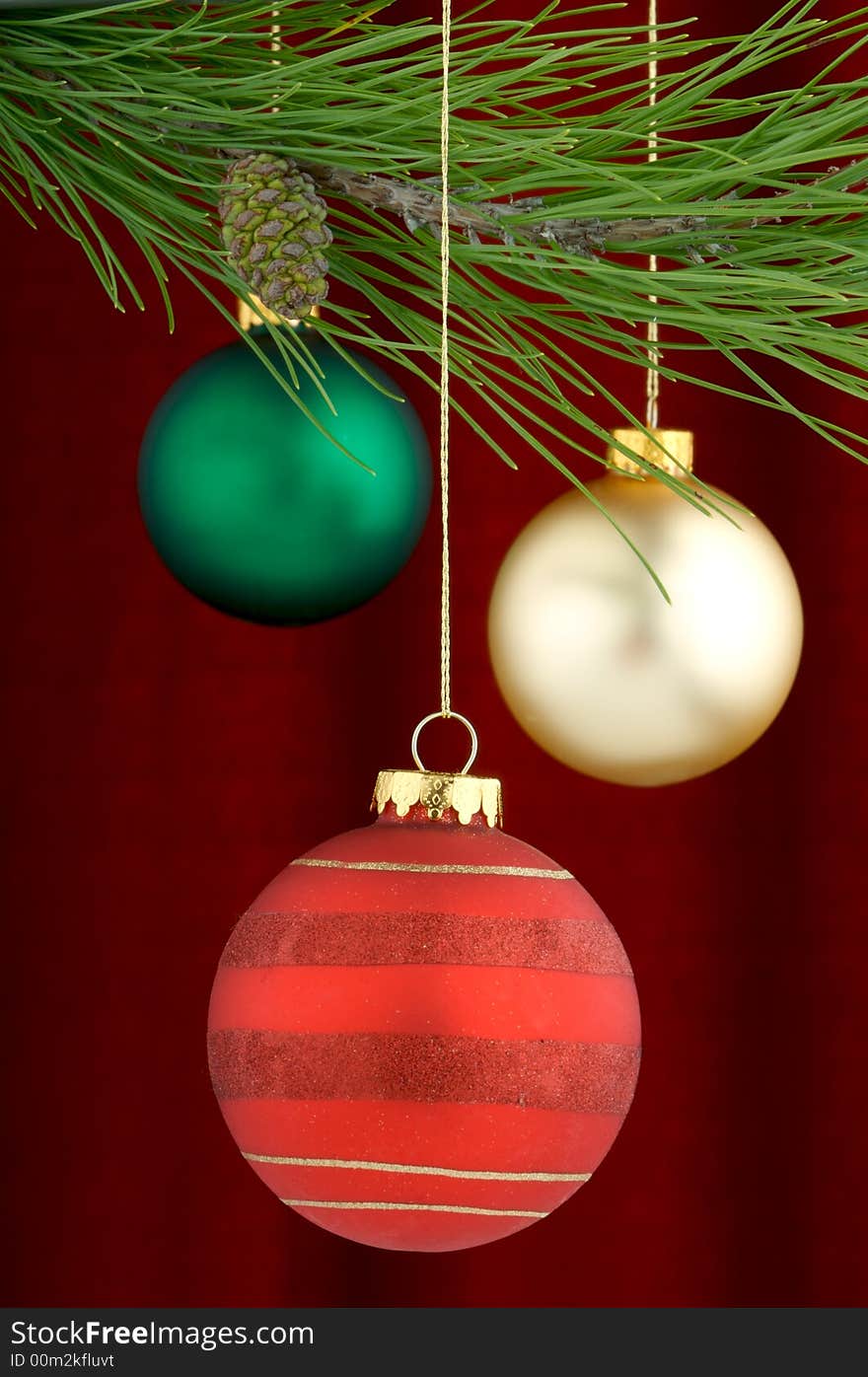 An image of multicolored Christmas ornaments on a burgundy background. An image of multicolored Christmas ornaments on a burgundy background