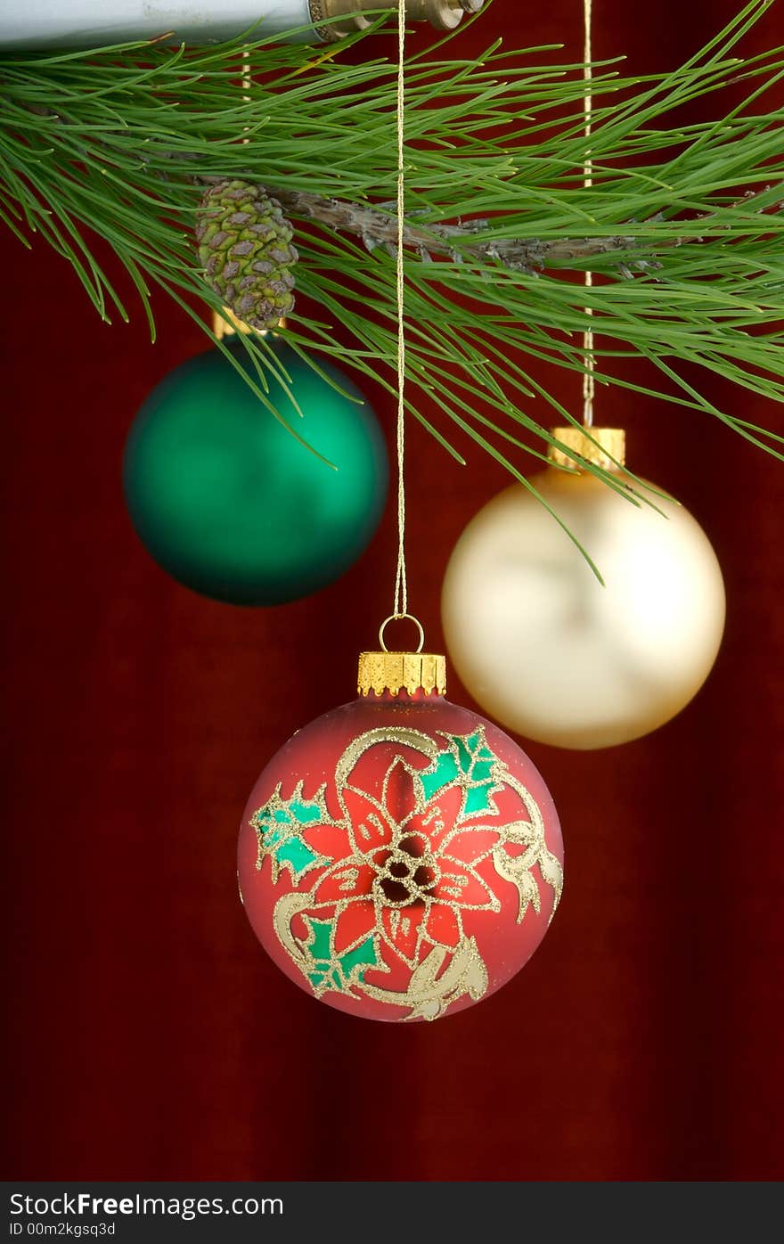 An image of multicolored Christmas ornaments on a burgundy background. An image of multicolored Christmas ornaments on a burgundy background