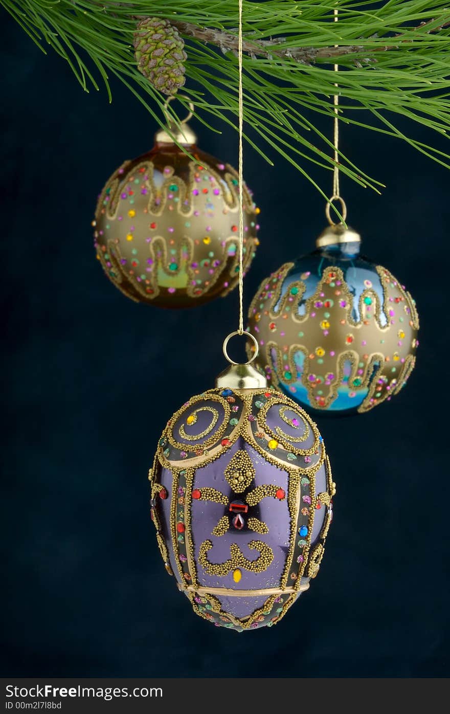 An image of multicolored Christmas ornaments on a burgundy background. An image of multicolored Christmas ornaments on a burgundy background