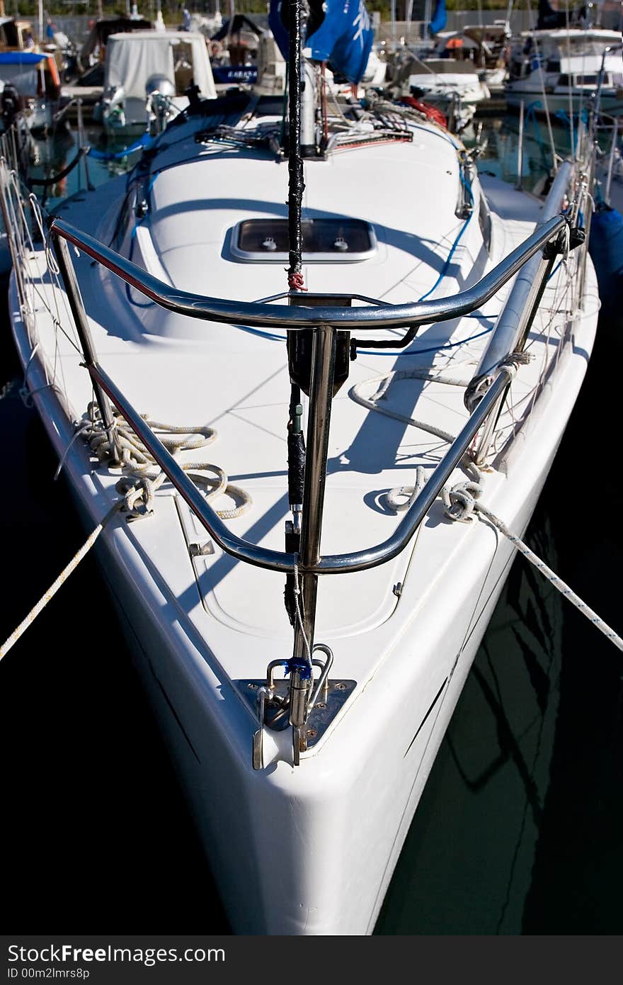 A small sailing boat moored in a marina. A small sailing boat moored in a marina