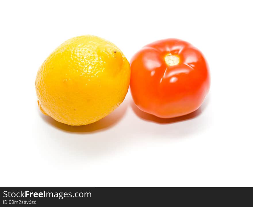 Ripe juicy tomato and lemon. Full isolation on white. Close-up.