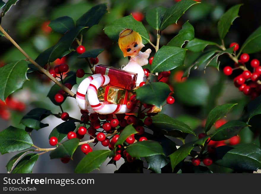 A Christmas angel ornament in holly with berry's. A Christmas angel ornament in holly with berry's