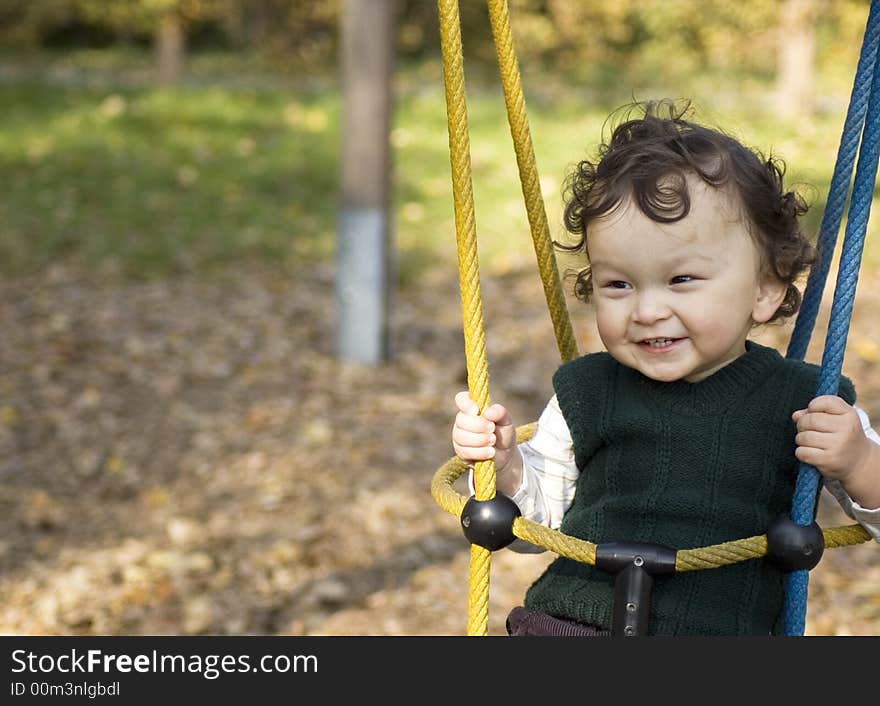 The small child shakes on a swing.