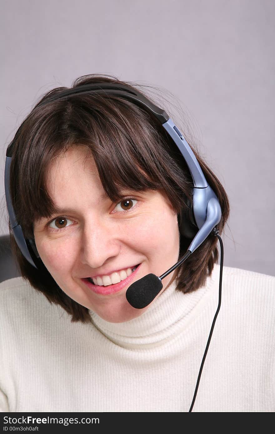 Smiley woman wearing headset on gray background. Smiley woman wearing headset on gray background