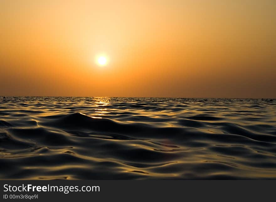 Sunset reflected in waves of the sea