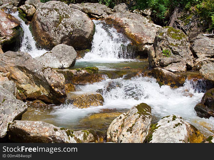 Mountain stream running over mossy rocks in siberia (foothills of Sayan's mountain range)