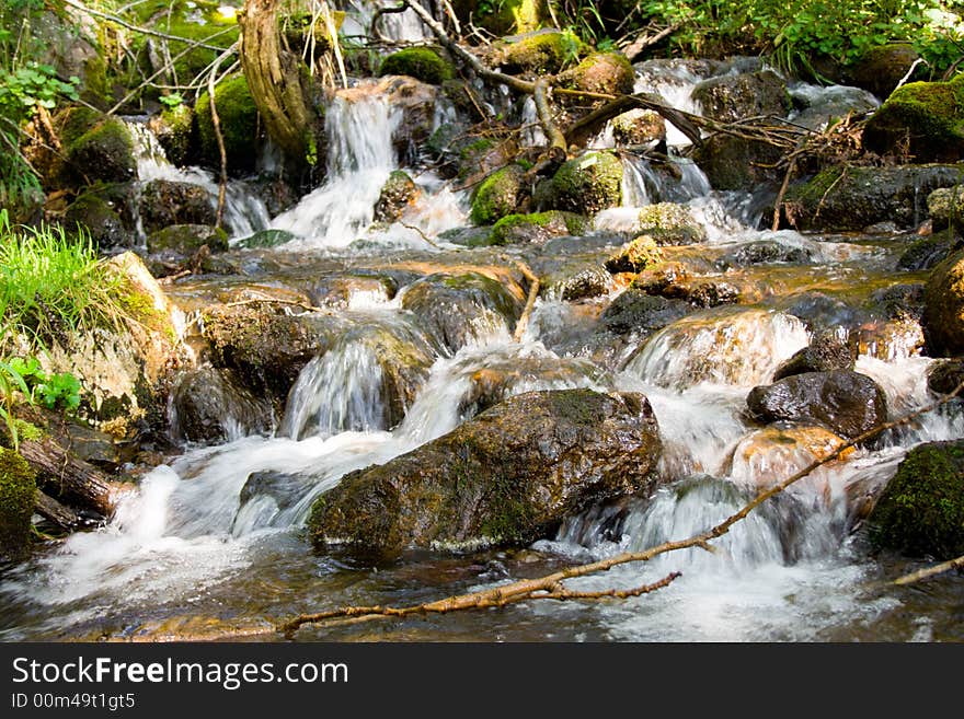 Mountain stream running over mossy rocks in siberia (foothills of Sayan's mountain range)