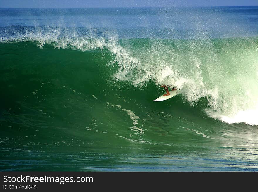 An image of a surfer doing a maneuver in the barrel. An image of a surfer doing a maneuver in the barrel.