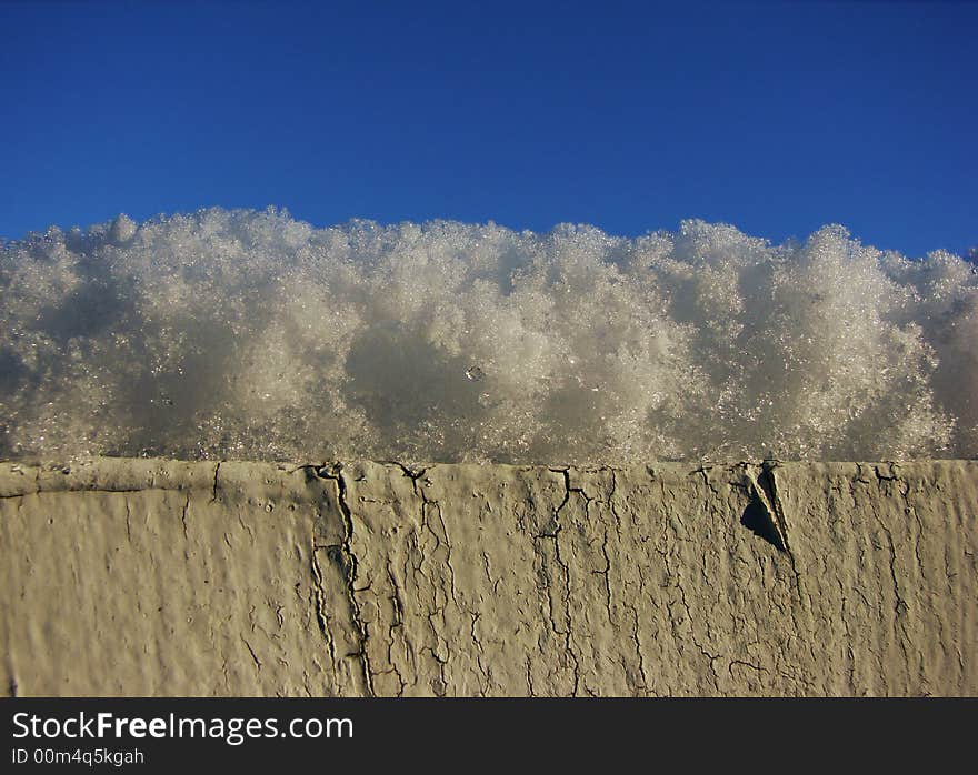 A macro shot of snow on top of a weathered wooden fence. Loads of copy space and sharp detail in the snow. A macro shot of snow on top of a weathered wooden fence. Loads of copy space and sharp detail in the snow.