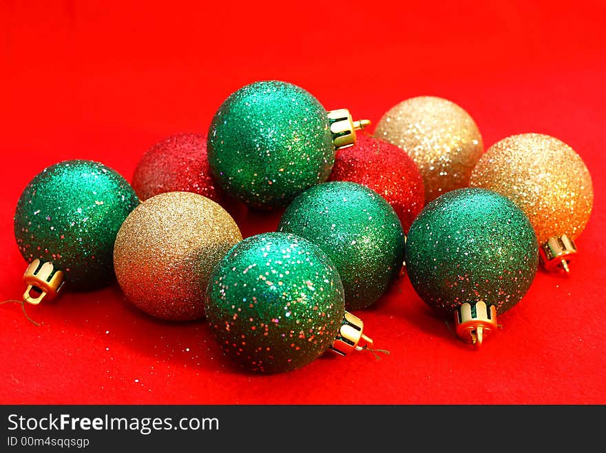 Green and gold christmas balls on a red background