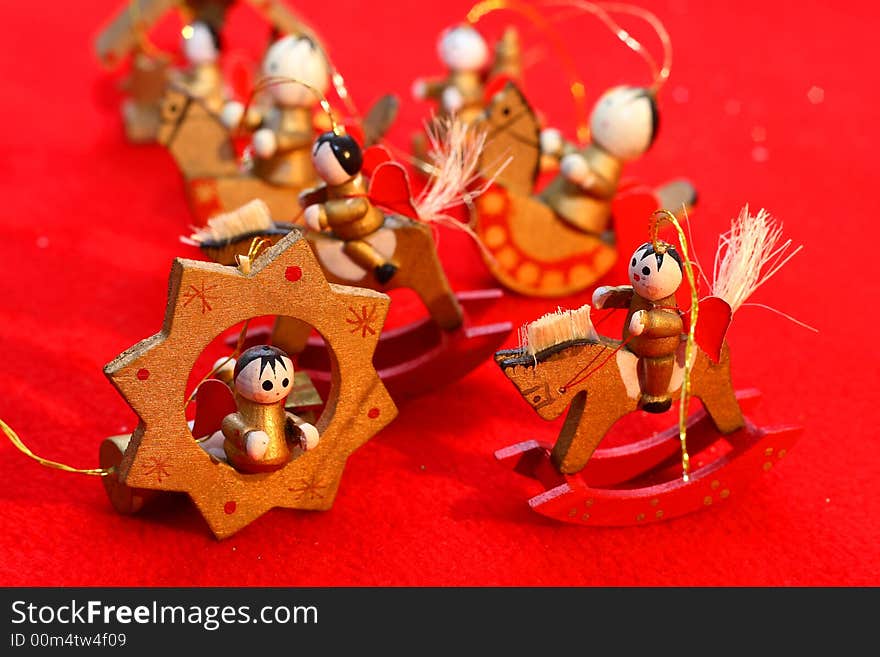 Little wooden new-year toys, wooden little angels on a red background