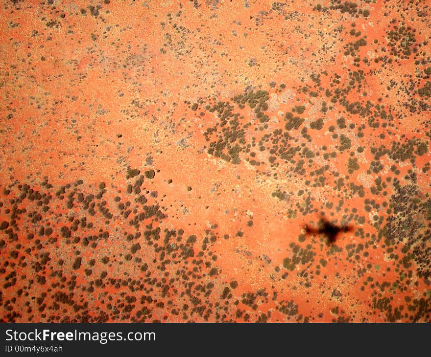 Photo taken over the Northern Territory desert from a commercial flight featuring a shadow of the aircraft. Photo taken over the Northern Territory desert from a commercial flight featuring a shadow of the aircraft