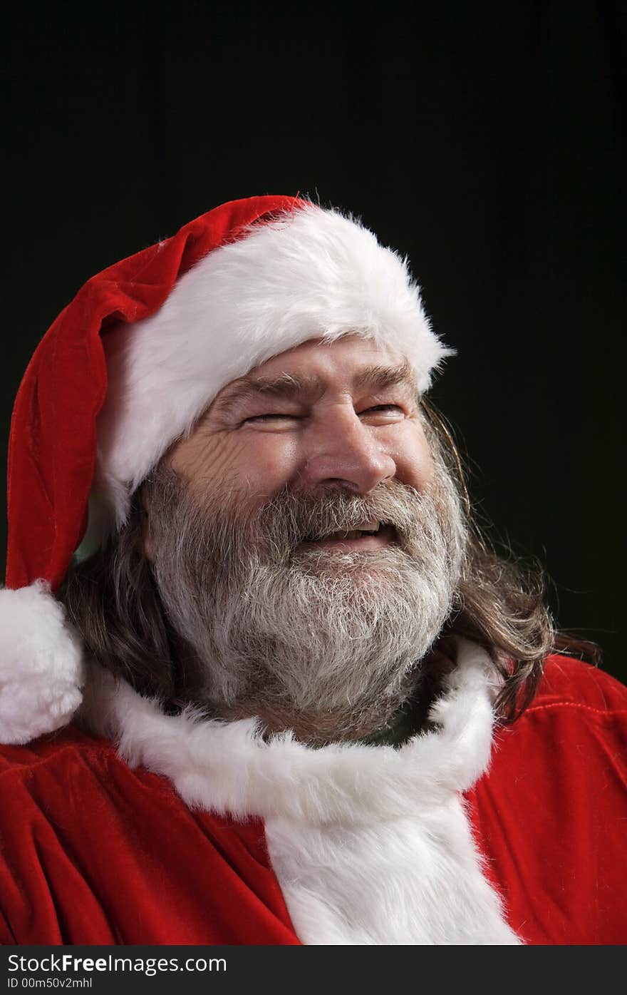 A young Santa with gray hair and beard having a good time