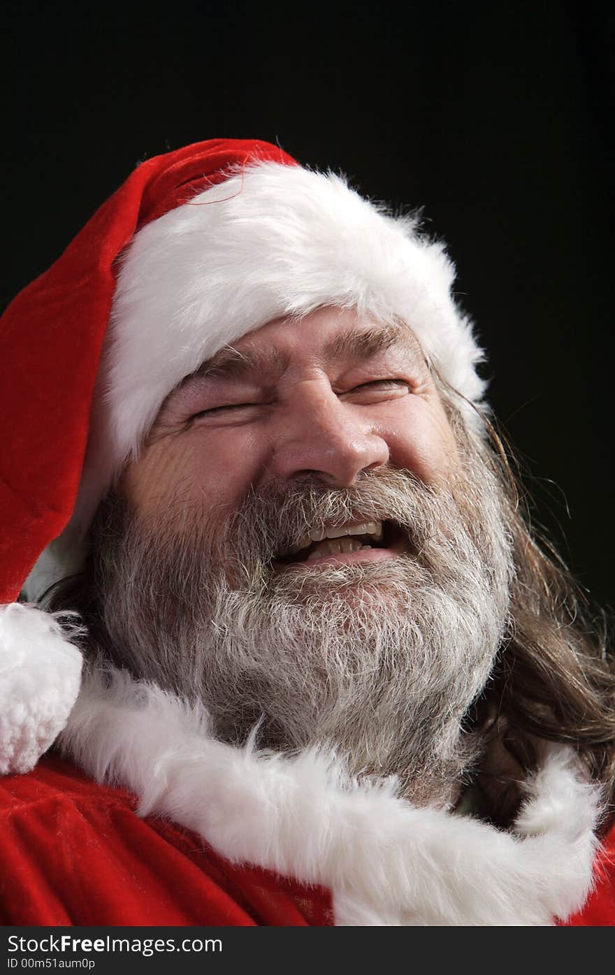 A young Santa with gray hair and beard having a good time