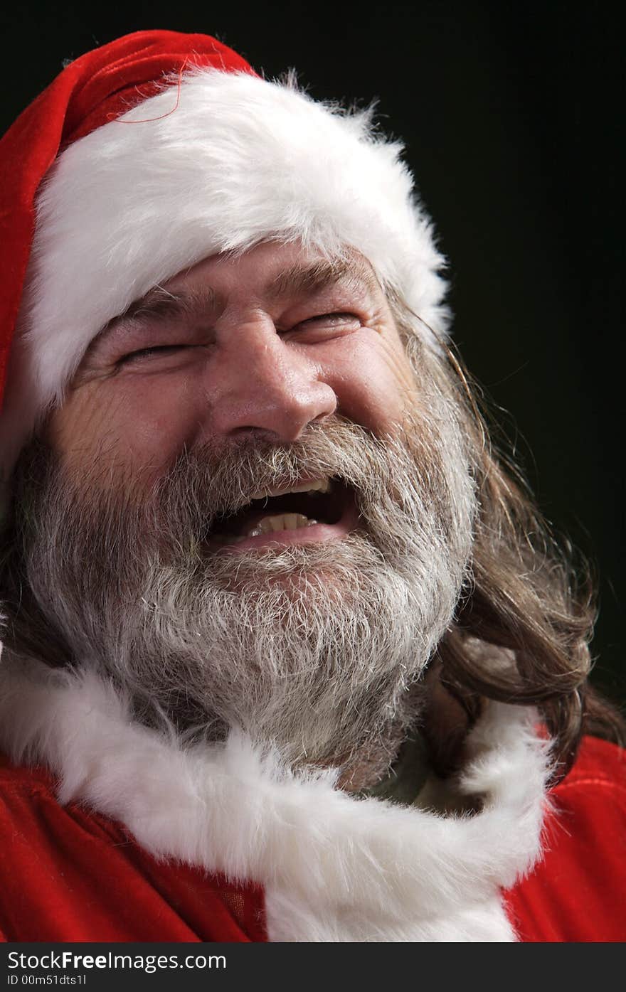 A young Santa with gray hair and beard having a good time