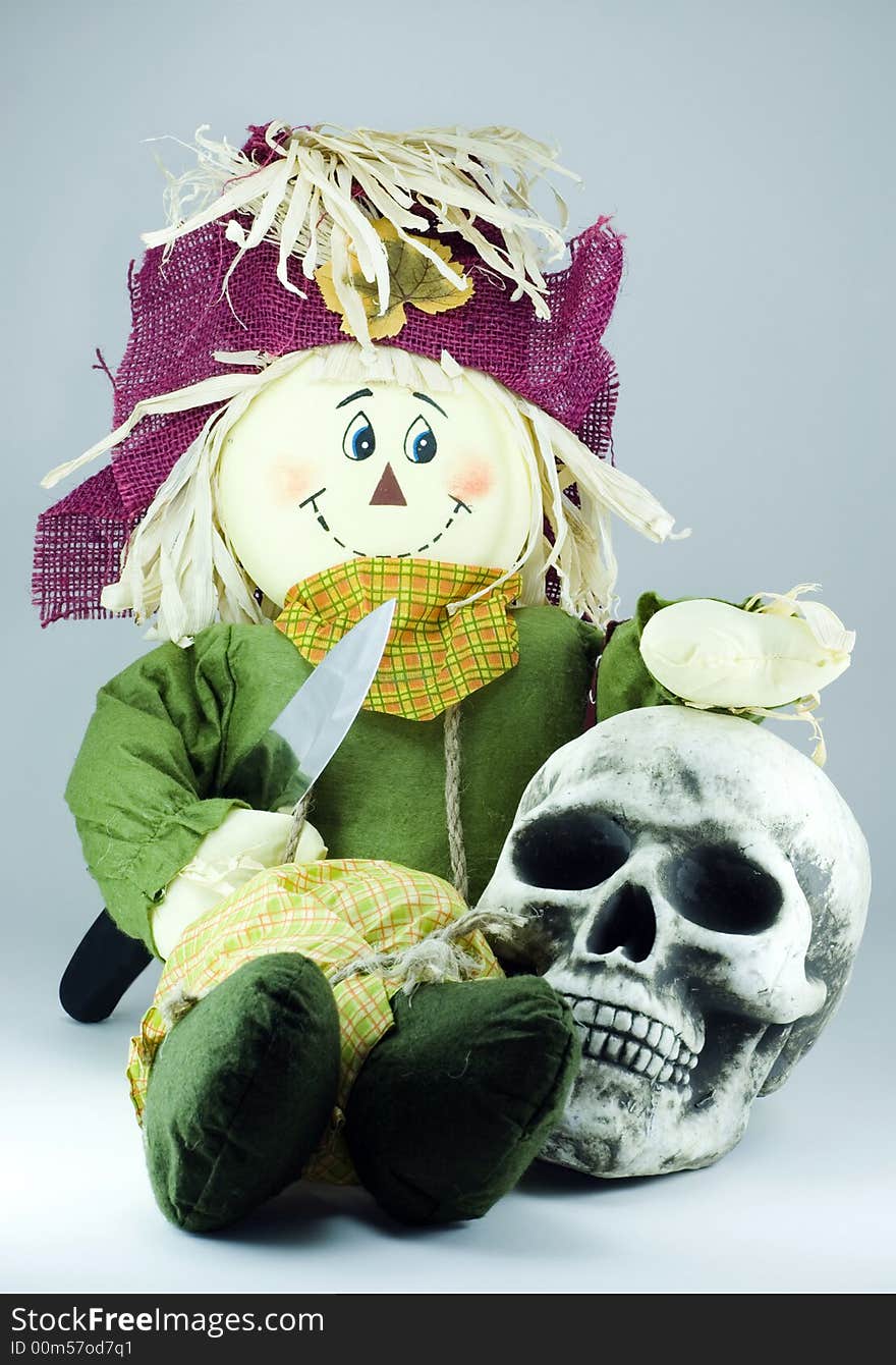 Scarecrow huging human skull and holding knife in the hands. Scarecrow huging human skull and holding knife in the hands