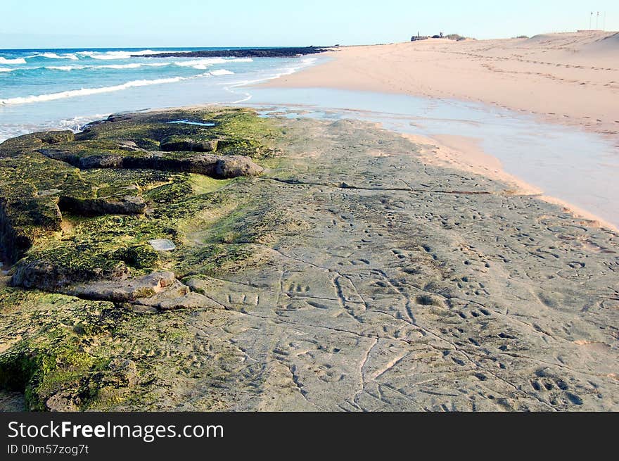 Rock or hard sand formations that show up at low tide, with different inscriptions. Corralejo beach, Fuerteventura, Canaries. Rock or hard sand formations that show up at low tide, with different inscriptions. Corralejo beach, Fuerteventura, Canaries.