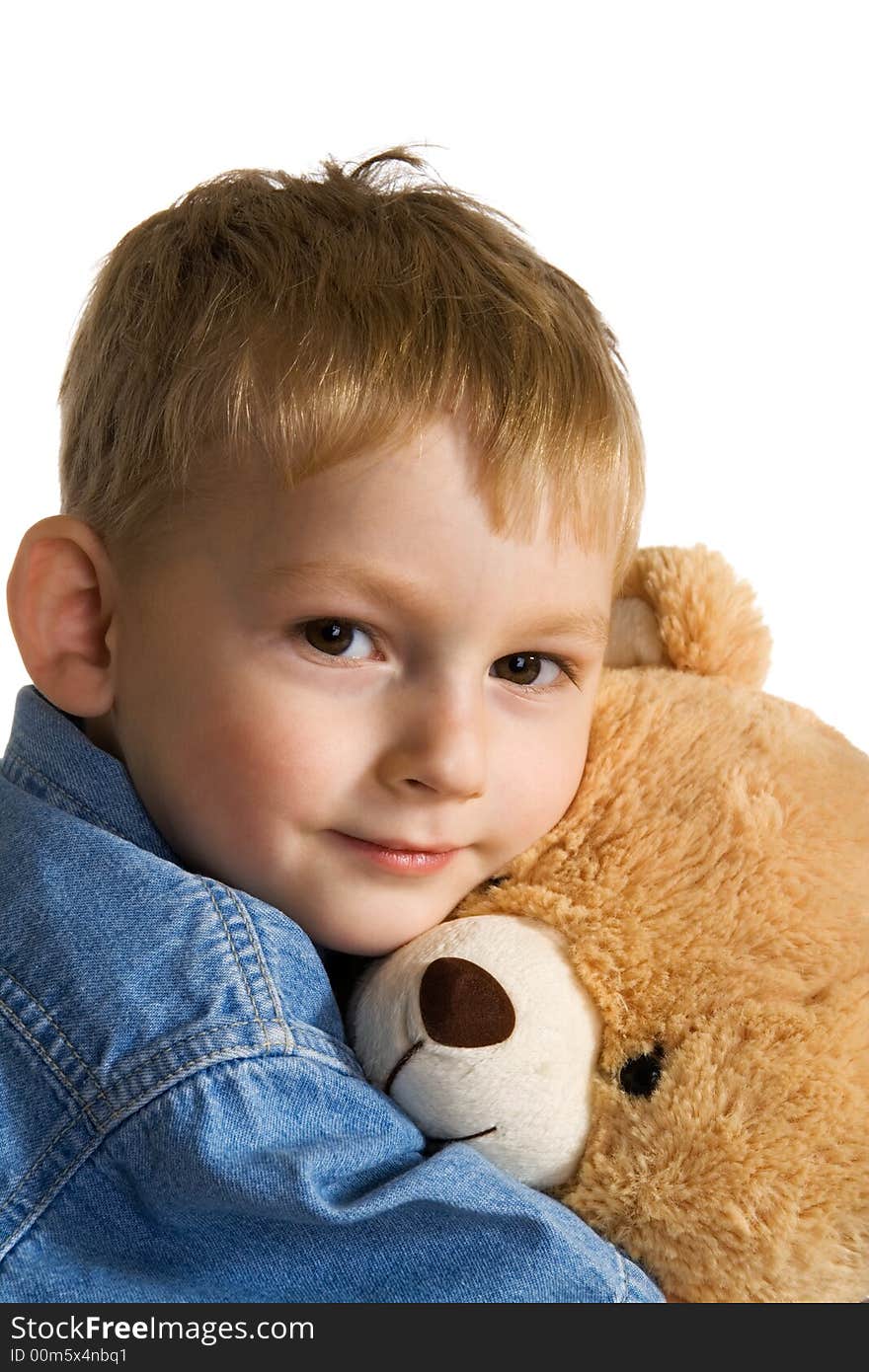 The little boy embraces a teddy bear