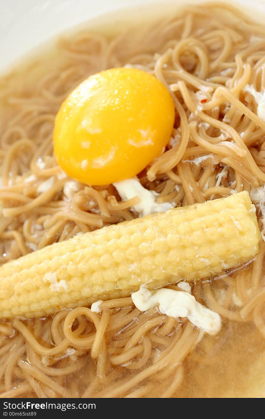 Brown Chinese buckwheat noodles with egg and baby corn in light soup